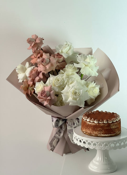 Bouquet of flowers and a cake on a light background