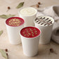 White coffee cups with cakes and with festive designs on a white surface