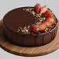 gluten-free raw vegan sugar-free Chocolate cake with strawberries on a wooden tray and gray background