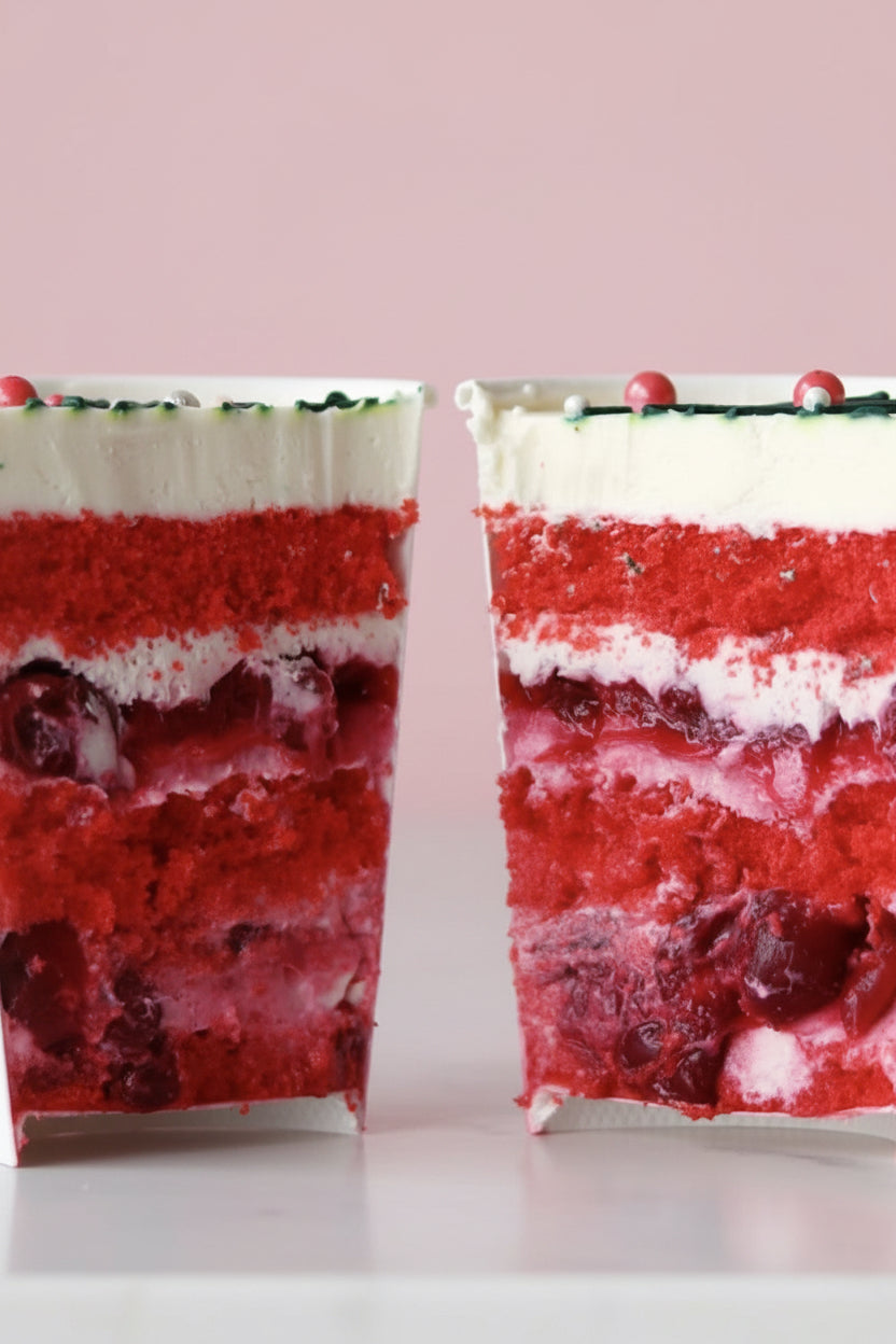 Two layered red and white dessert cups with a blurred background