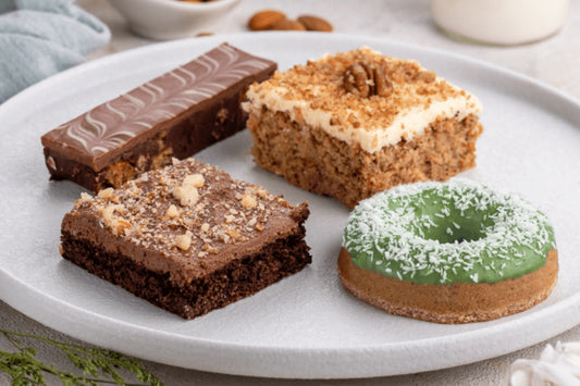 Assorted desserts including brownies and a donut on a white plate.