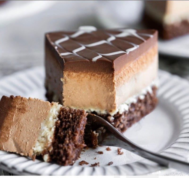 Slice of gluten-free vegan chocolate coconut cheesecake cake on a plate with a fork