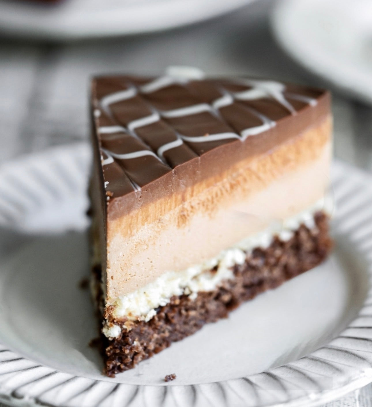 Slice of  gluten-free vegan layered cake on a white plate with blurred background