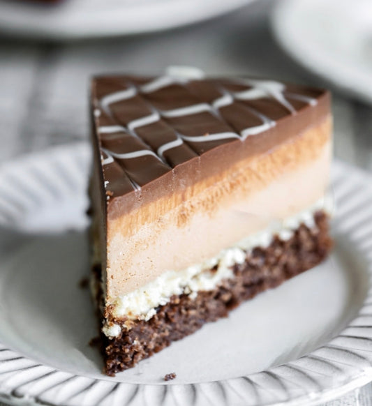 Slice of gluten-free vegan layered cake on a white plate with blurred background