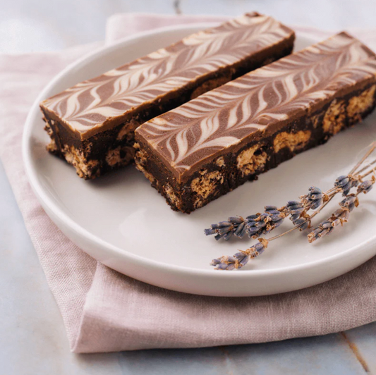 Two chocolate bars with a marbled pattern on a white plate with lavender flowers.