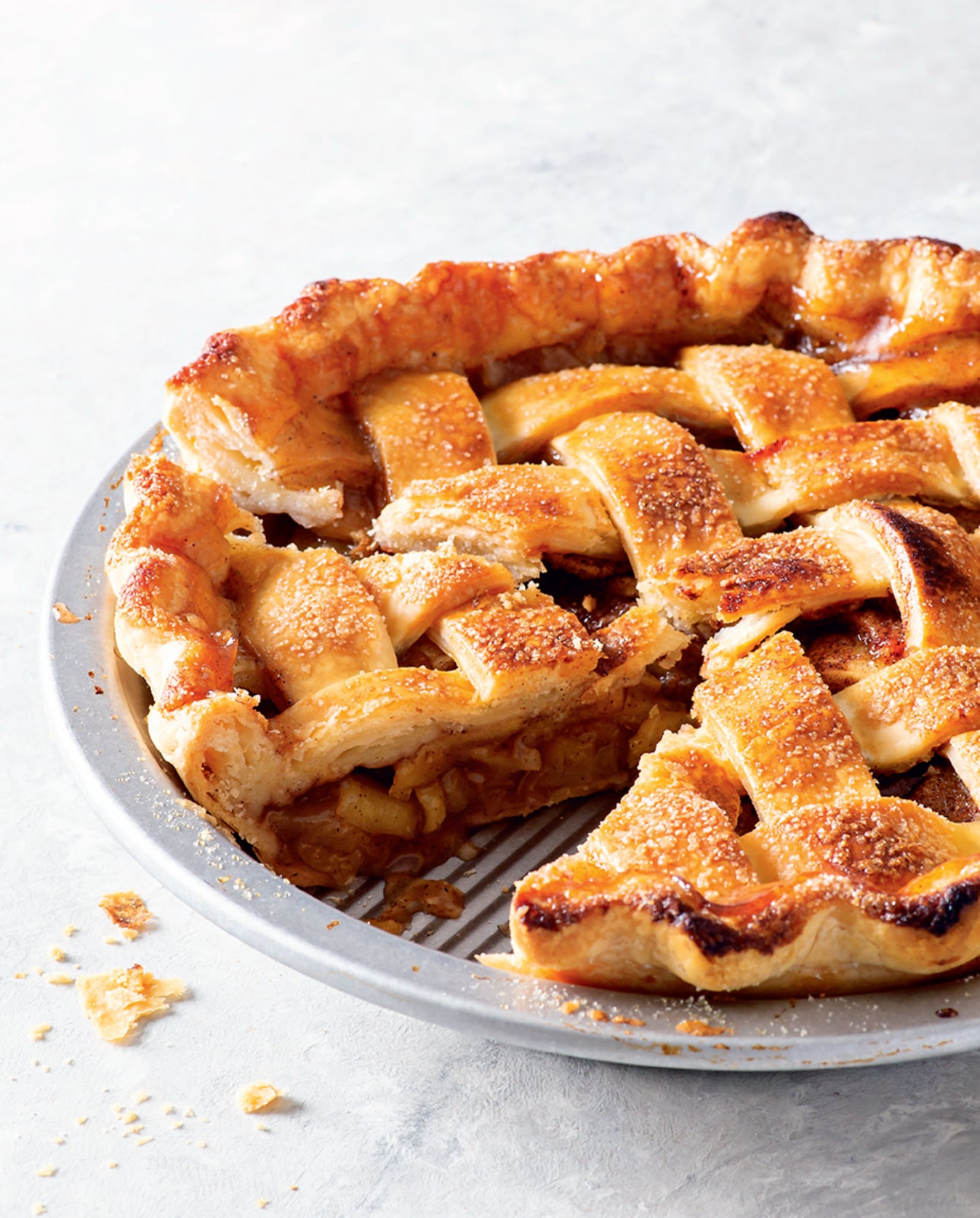 Apple pie with a slice removed on a white plate