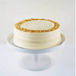 Cake with white frosting and crumbly topping on a white cake stand against a white background